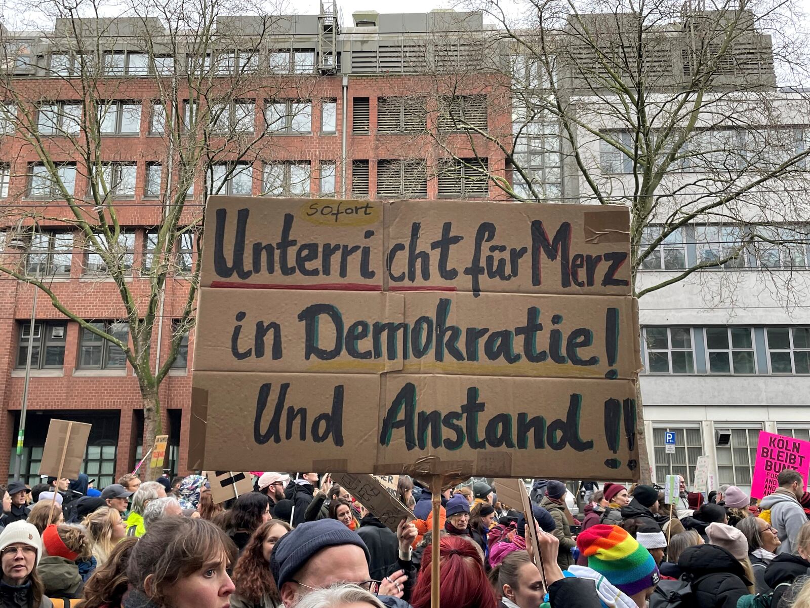 People gather to protest against the Far Right, in Cologne, Germany, Saturday Jan. 25, 2025. Banner reads: "Immediate lessons for Merz in democracy and decency". (Christoph Driessen/dpa via AP)