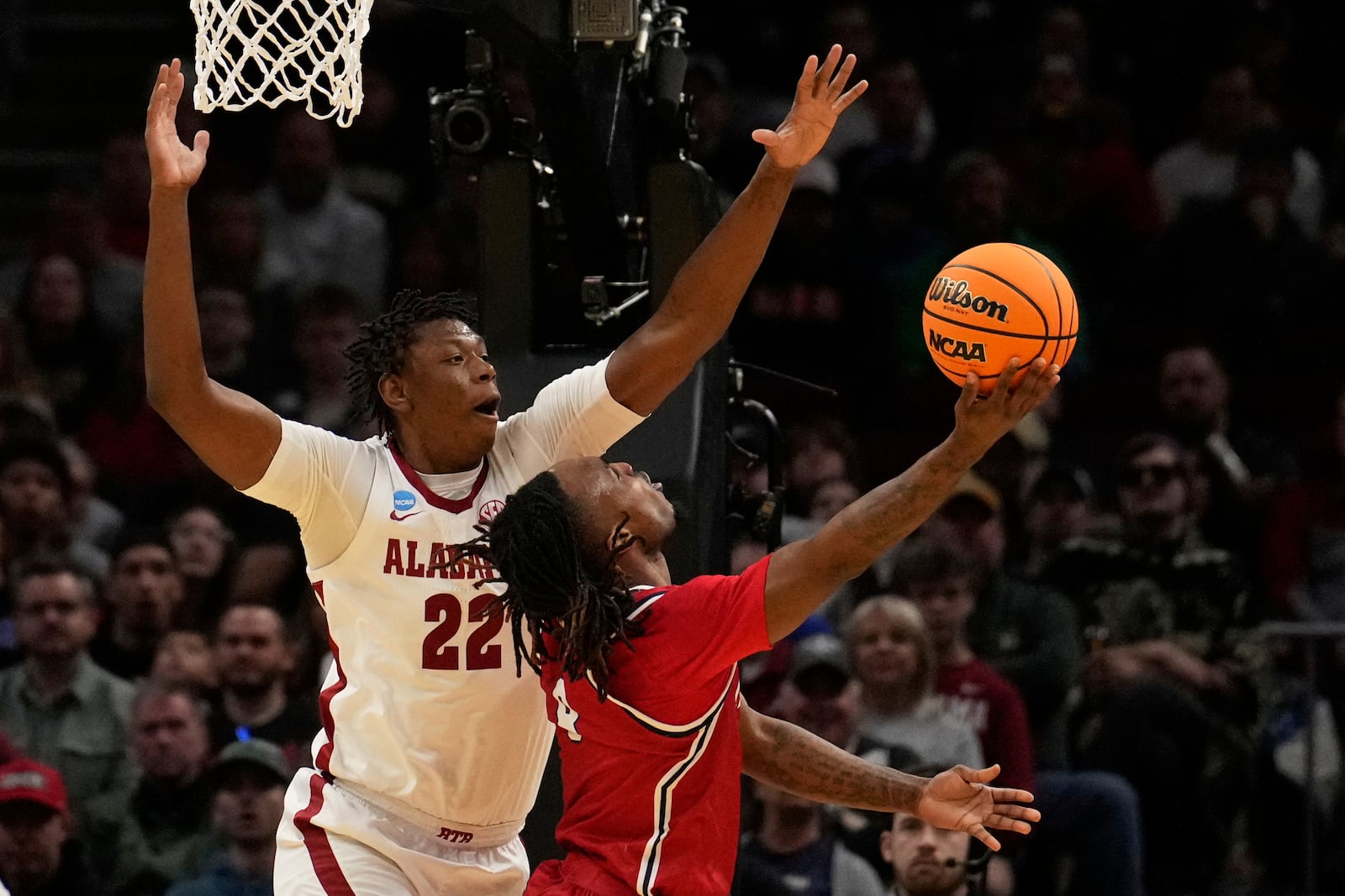 Robert Morris guard Josh Omojafo (4) shoots as Alabama forward Aiden Sherrell (22) defends in the first half in the first round of the NCAA college basketball tournament, Friday, March 21, 2025, in Cleveland. (AP Photo/Sue Ogrocki)