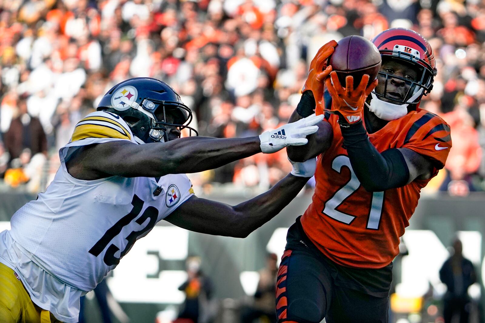 Cincinnati Bengals cornerback Mike Hilton (21) makes an interception of a pass intended for Pittsburgh Steelers wide receiver James Washington (13) during the first half of an NFL football game, Sunday, Nov. 28, 2021, in Cincinnati. Hilton returned the ball for a touchdown. (AP Photo/Jeff Dean)