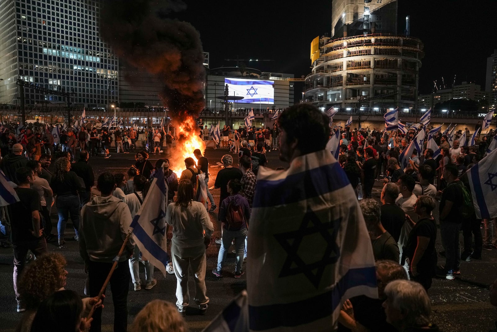 Israelis light a bonfire during a protest after Prime Minister Benjamin Netanyahu has dismissed his popular defense minister Yoav Gallant, in Tel Aviv, Israel, Tuesday, Nov. 5, 2024. (AP Photo/Oded Balilty)