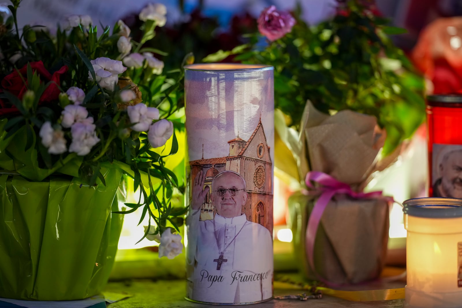 Candles and flowers for Pope Francis are laid in front of the Agostino Gemelli Polyclinic, in Rome, Wednesday, March 19, 2025, where the Pontiff is hospitalized since Friday, Feb. 14. (AP Photo/Andrew Medichini)