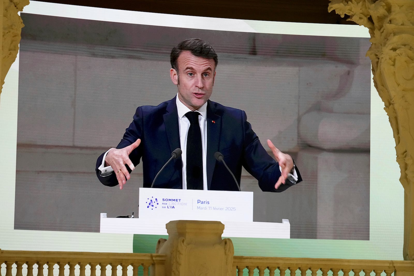 French President Emmanuel Macron is projected on a large screen as he addresses the audience in a closing speech at the Grand Palais during the Artificial Intelligence Action Summit in Paris, Tuesday, Feb. 11, 2025. (AP Photo/Michel Euler)