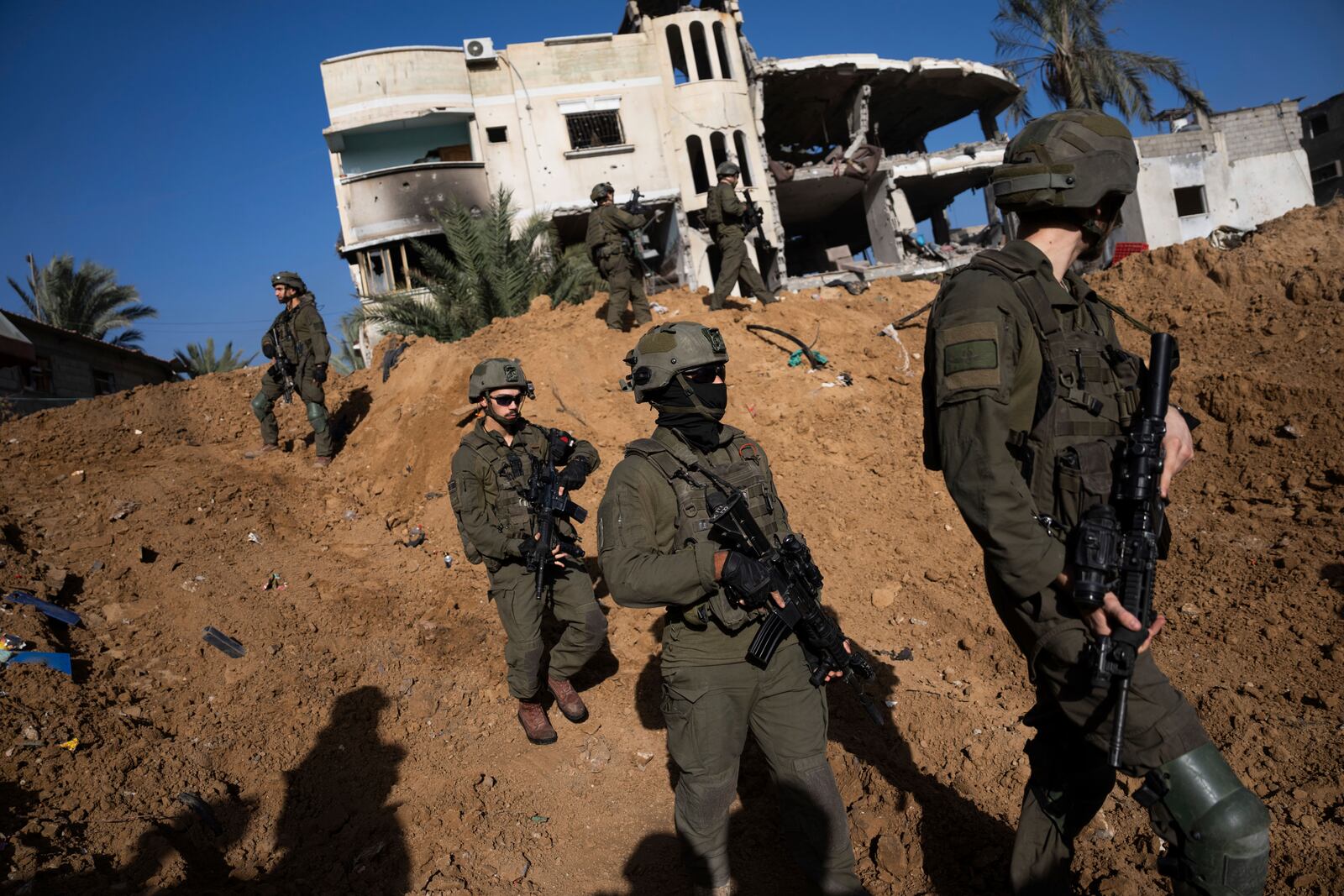 FILE - Israeli army troops walk near a destroyed building during a ground operation in Khan Younis, Gaza Strip, Jan. 10. 2024. (AP Photo/Ohad Zwigenberg, File)