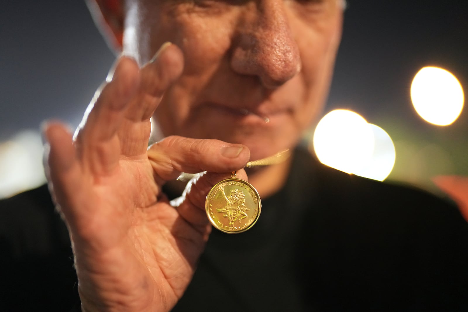 Cliff Housego shows a participatory medal for LA Marathon before the race Sunday, March 16, 2025, in Los Angeles. (AP Photo/Eric Thayer)