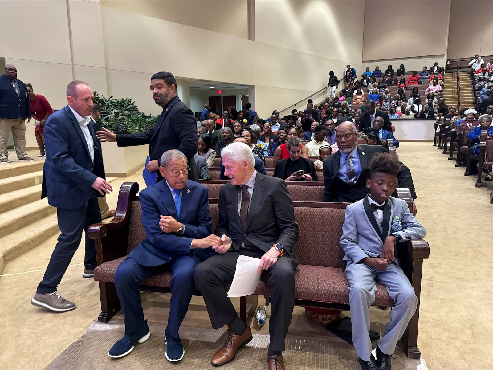 Former President Bill Clinton and US Rep. Sanford Bishop talk while seated at Mt. Zion Baptist Church in Albany, Ga. on Sunday, Oct. 13, 2024. (AP Photo/Charlotte Kramon)