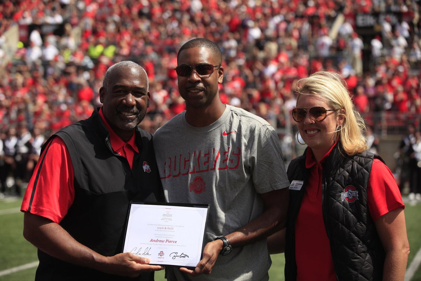 Yellow Springs graduate Andrew Pierce (center) is honored during the Ohio State Hall of Fame ceremony at halftime of a game between the Buckeyes and Cincinnati on Saturday, Sept. 7, 2019, at Ohio Stadium in Columbus. David Jablonski/Staff