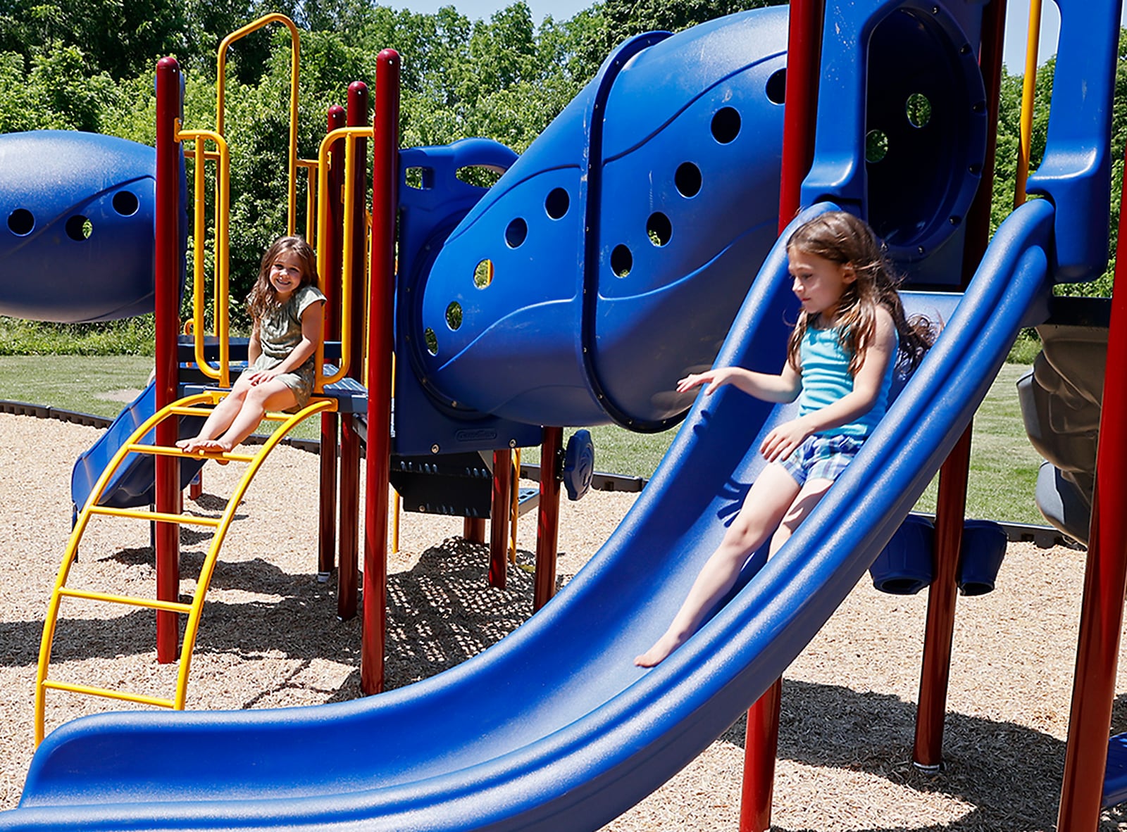 Adrian Massie and her sister, Arrionna, play on the new playground at New Reid Park Thursday. BILL LACKEY/STAFF