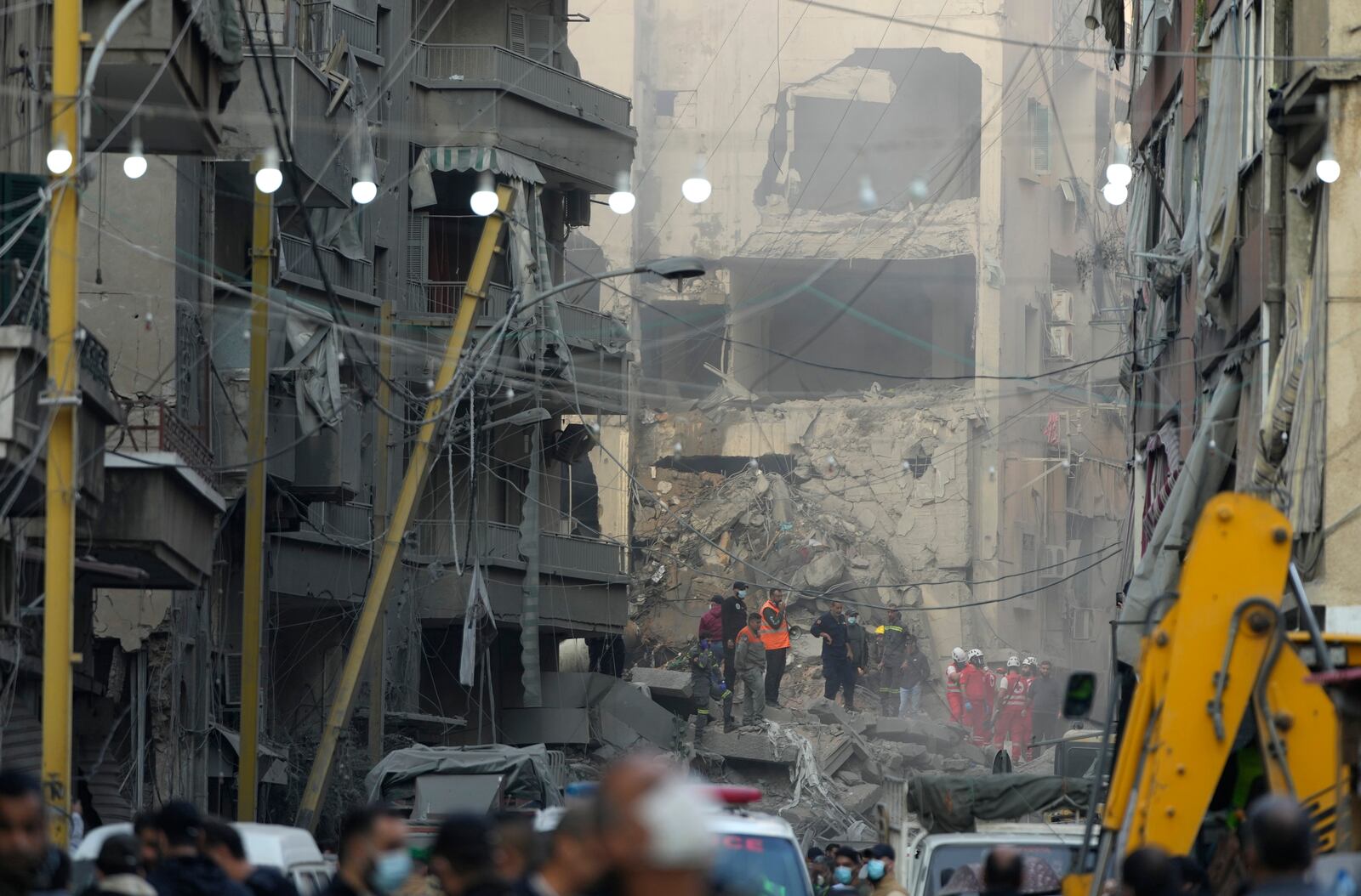 Rescue workers and people gather at the site of an Israeli airstrike that hit central Beirut, Lebanon, Saturday, Nov. 23, 2024. (AP Photo/Hassan Ammar)