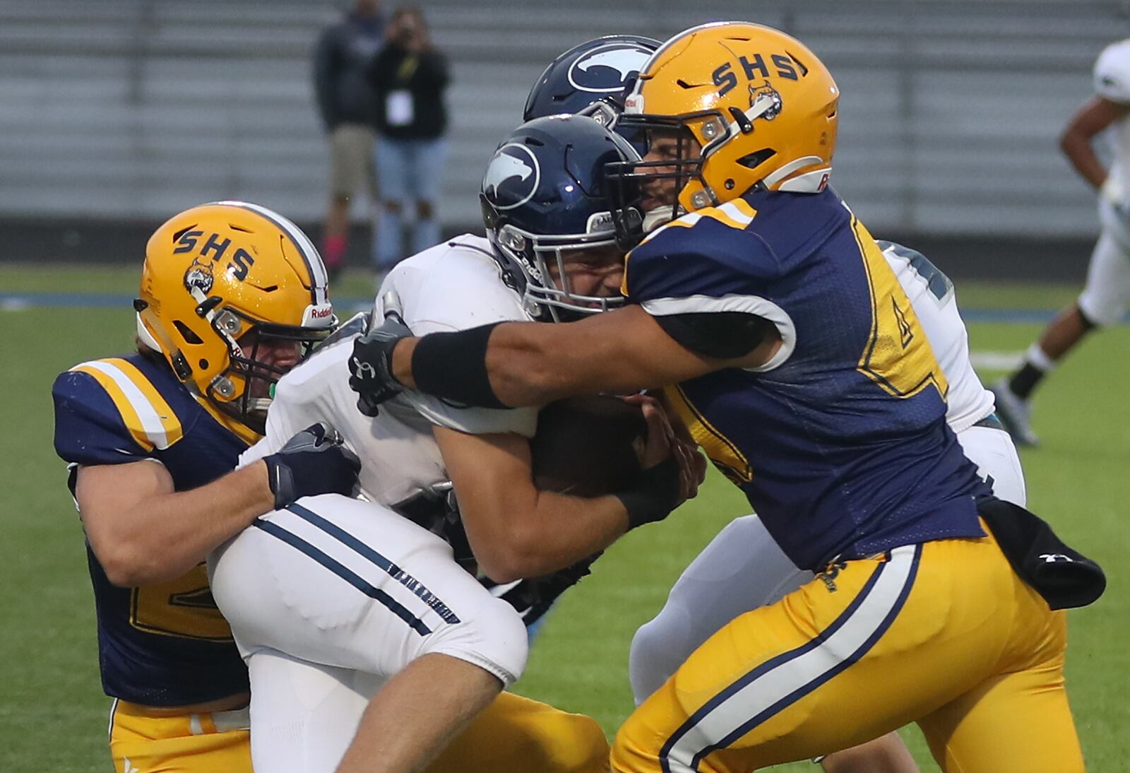 Springfield's Bryce Sherrock, left, and Jayden McKinster try to stop Fairmont's Drew Baker as he carries the ball during Friday's game. BILL LACKEY/STAFF