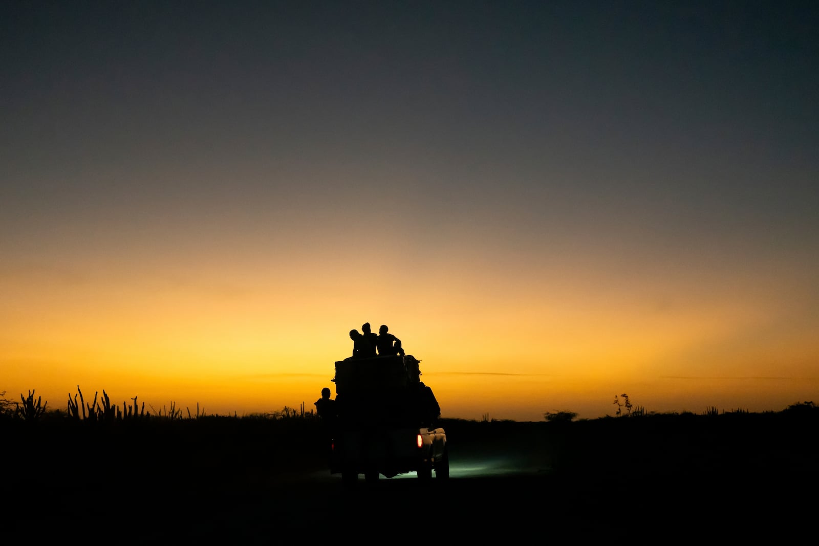 A car transporting passengers and supplies travels as the sun sets toward Cabo de la Vela, Colombia, Thursday, Feb. 6, 2025. (AP Photo/Ivan Valencia)