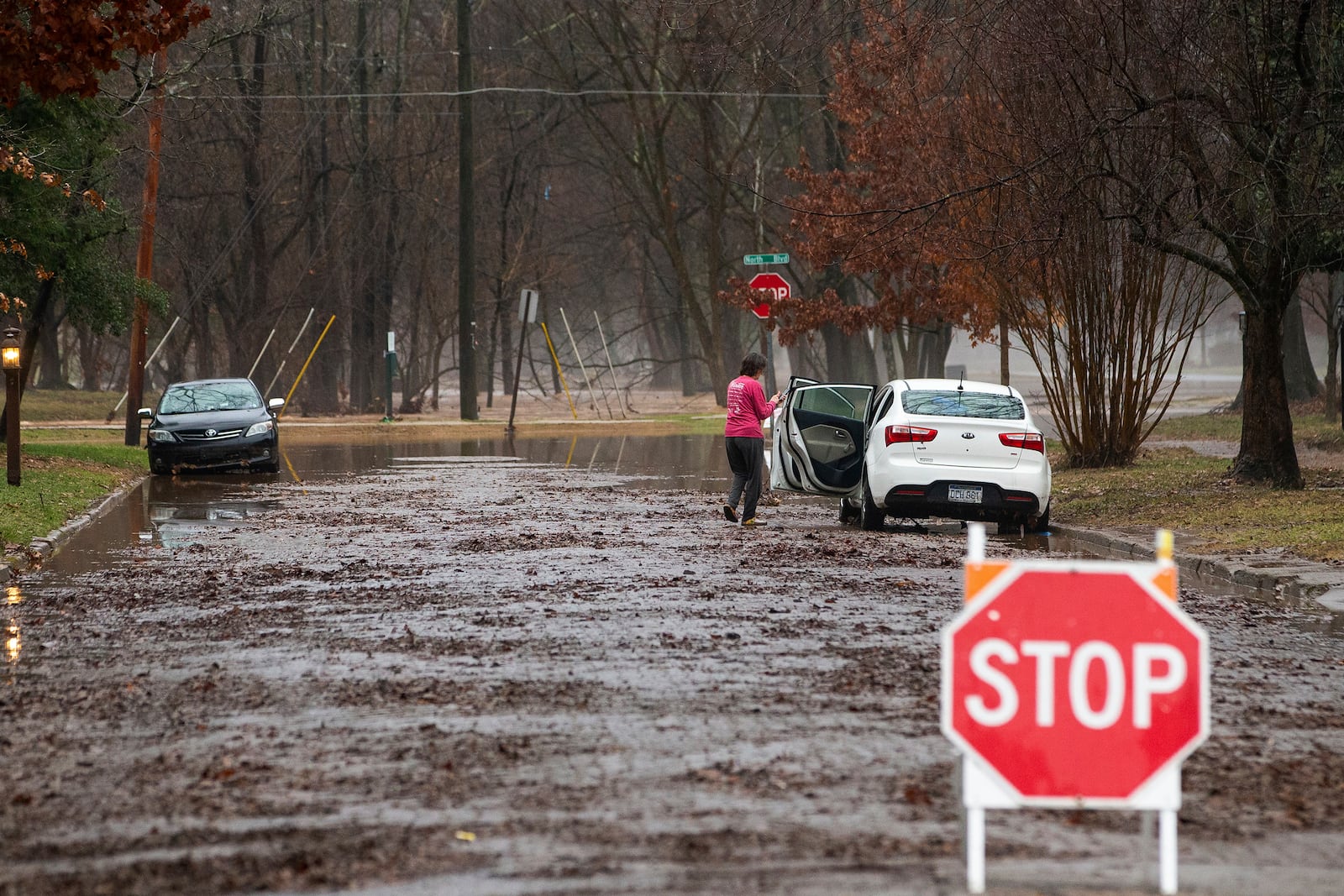 People parked along 13th Avenue check their vehicles for water damage as flooding impacts parts of the Southside neighborhood on Thursday, Feb. 6, 2025, in Huntington, W.Va. (Ryan Fischer/The Herald-Dispatch via AP)