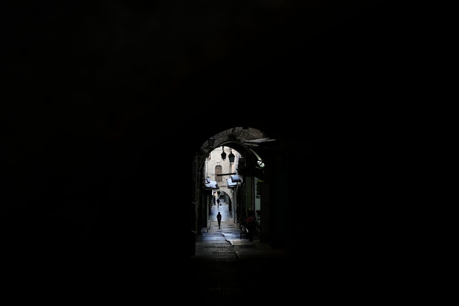 Pedestrians walk through an alley of Jerusalem's Old City, Tuesday, Dec. 3, 2024. (AP Photo/Matias Delacroix)