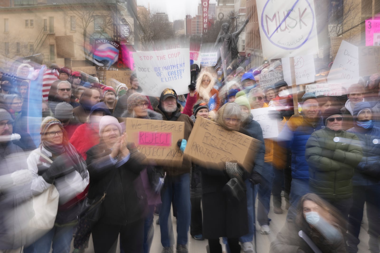 People hold up signs during a protest outside the Wisconsin Capitol Wednesday, Feb. 5, 2025, in Madison, Wis. (AP Photo/Morry Gash)