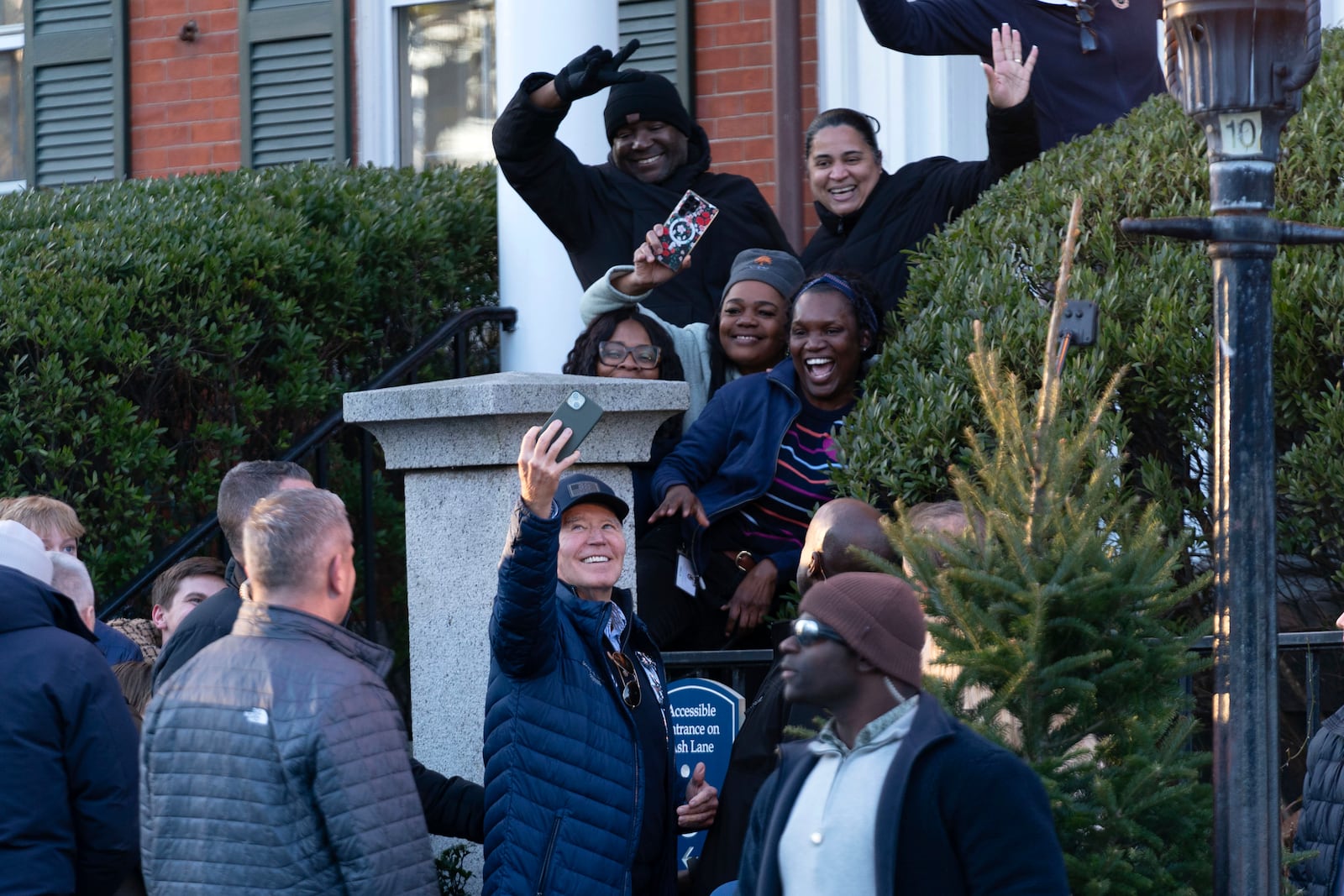 President Joe Biden takes a selfie with people as he walks in downtown Nantucket, Mass., Friday, Nov. 29, 2024. (AP Photo/Jose Luis Magana)