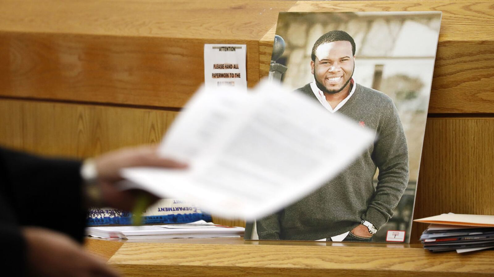 A photo of Botham Jean leans against the judge's bench Tuesday, Sept. 24, 2019, during the murder trial of ex-Dallas police officer Amber Guyger. Guyger is accused of killing Jean, a neighbor, last year after mistaking his apartment for her own.