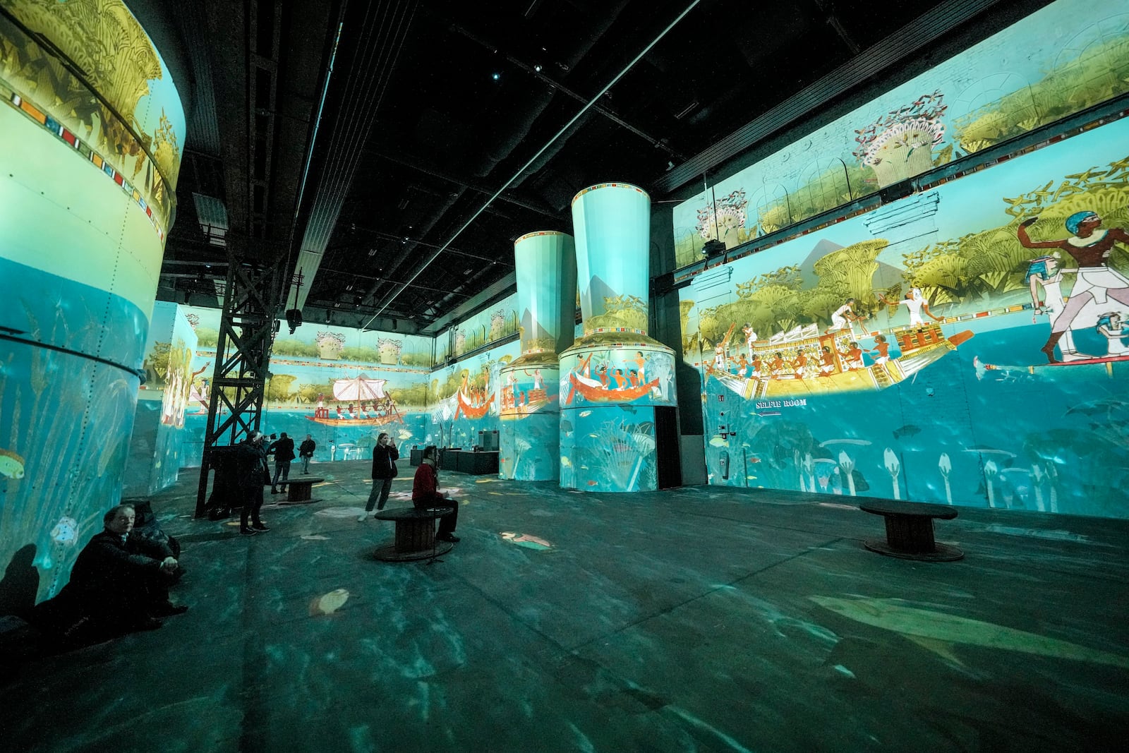 FILE - Visitors watch the audiovisual immersive ancient Egypt presentation 'The Kingdom of the Pharaohs', projected on the walls of a former steelworks at the Phoenix des Lumieres exhibition in Dortmund, Germany, Thursday, Jan. 23, 2025. (AP Photo/Martin Meissner, File)