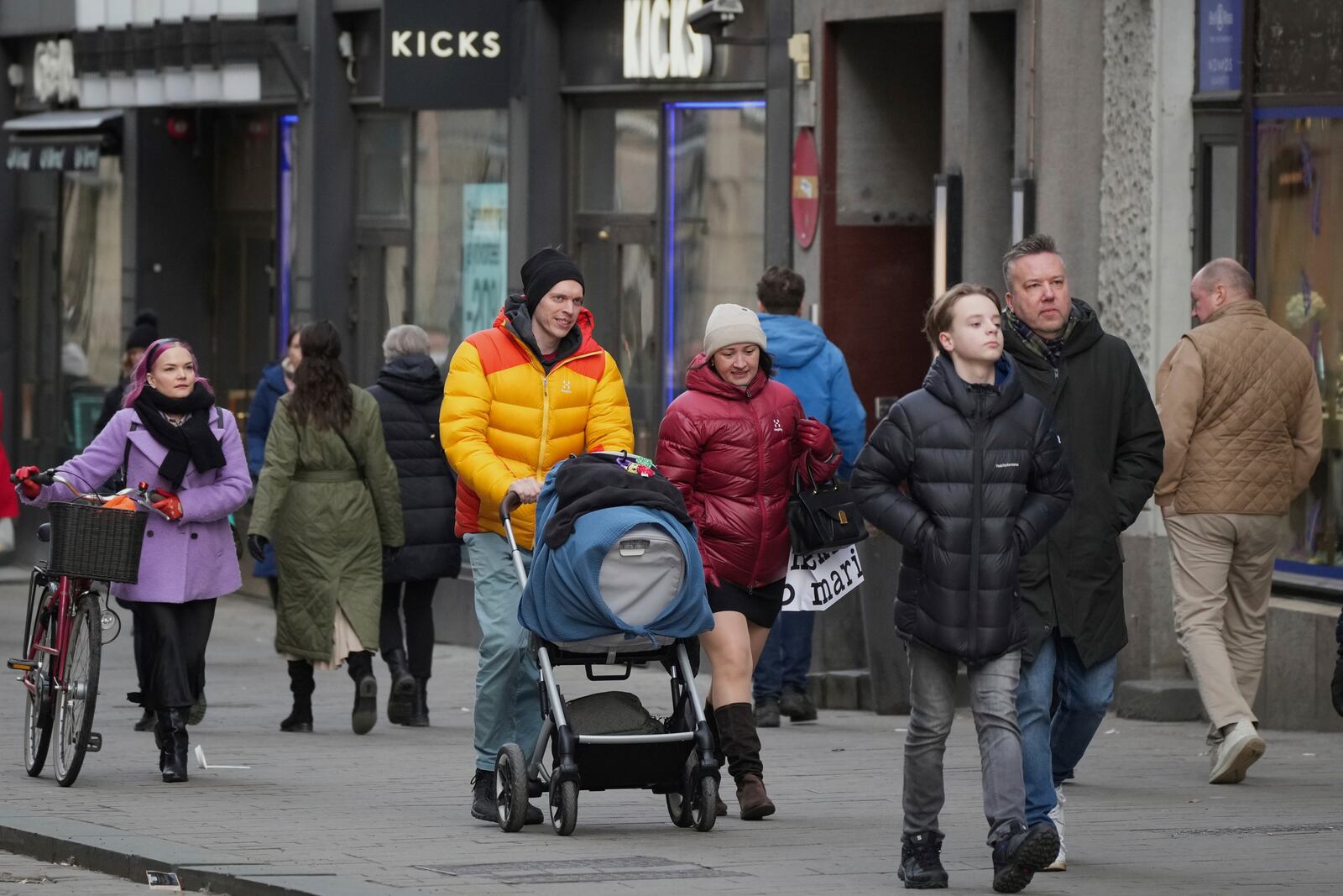 People walk along a shopping street in the center of Helsinki, Finland, Saturday, March 15, 2025. (AP Photo/Sergei Grits)