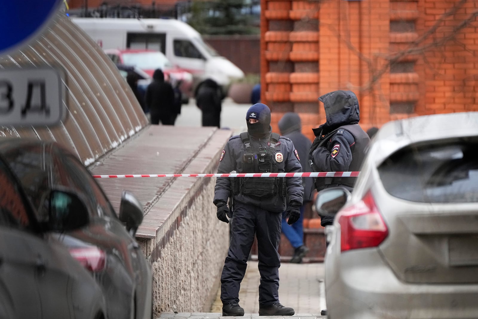 Police officers stand guard at the entrance to the yard of an upscale residential block in Moscow, Russia, Monday, Feb. 3, 2025, where the blast has killed one person and wounded four others, Russian news agencies say. (AP Photo/Alexander Zemlianichenko)