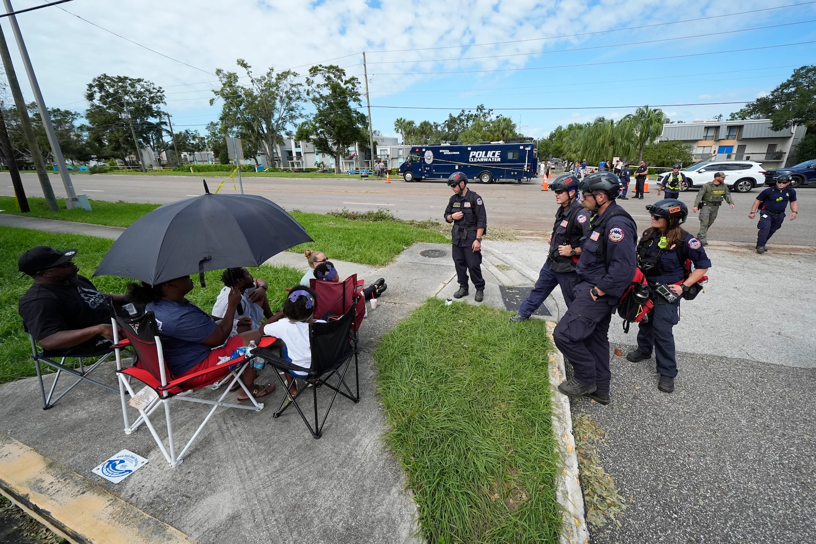 FEMA officials talk to residents displaced out of their apartment complex during Hurricane Milton, Friday, Oct. 11, 2024, in Clearwater, Fla. (AP Photo/Julio Cortez)