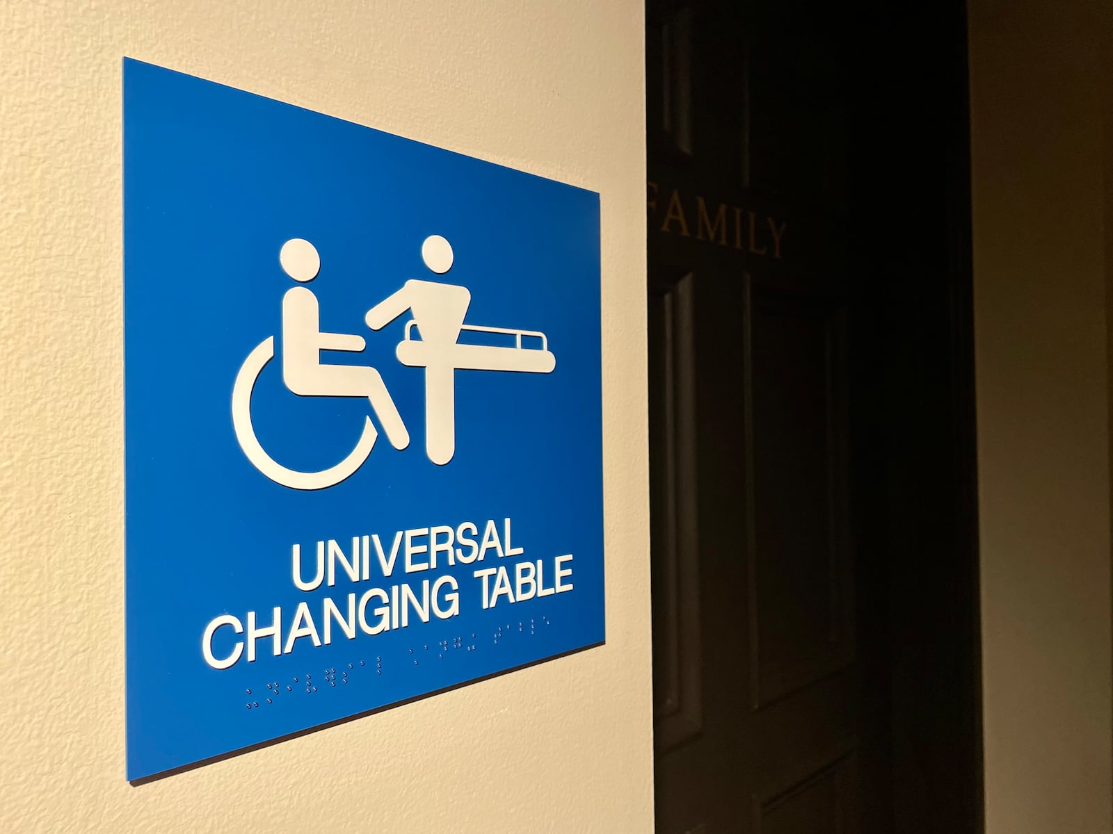 A sign shows that the family restroom at Dayton Art Institute contains a universal changing table within.