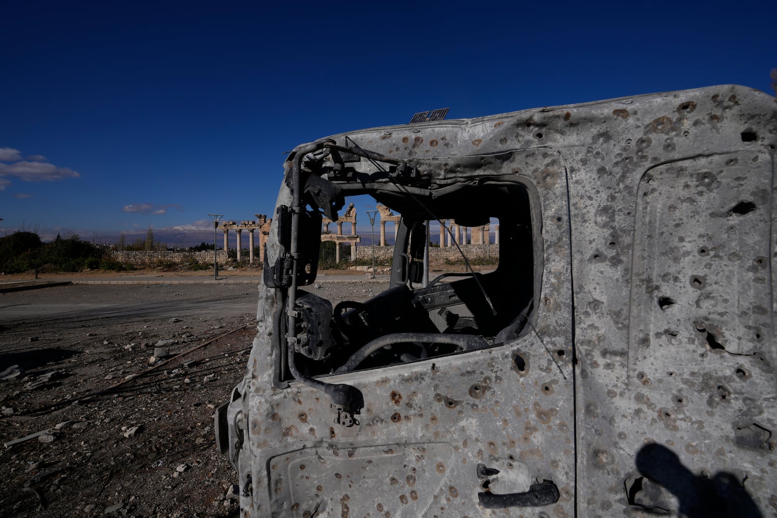 A damaged vehicle seen in front of part of the Roman temples of Baalbek in eastern Lebanon, Thursday, Nov. 28, 2024. (AP Photo/Hassan Ammar)