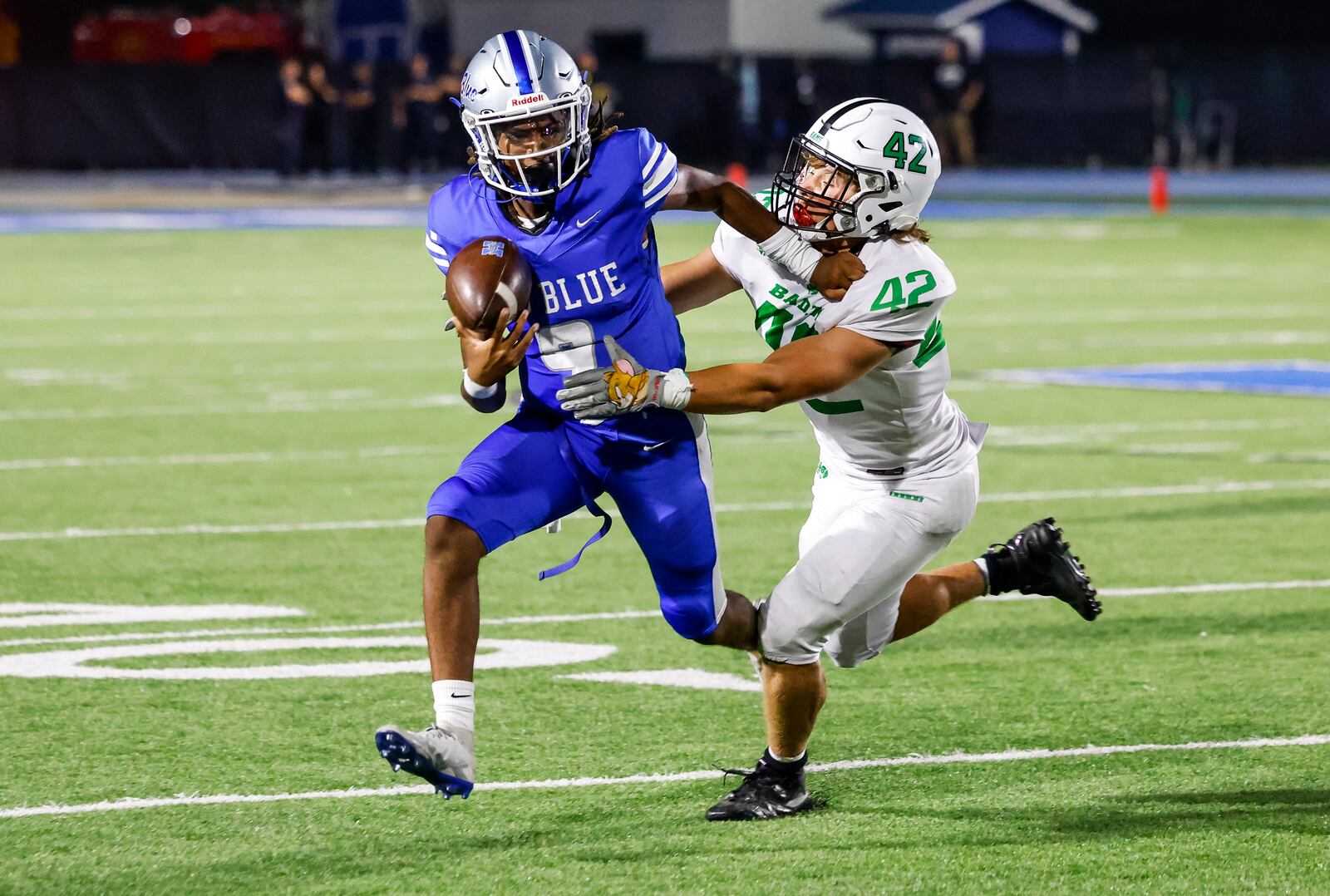 Hamilton quarterback Antonio Mathis Jr. carries the ball defended by Badin's Nate Ostendorf during their football game Friday, Aug. 18, 2023 at Hamilton's Virgil Schwarm Stadium. Badin defeated Hamilton 18-0 during the showdown at the Schwarm. This is the first football game between the cross town teams since the year 2000. NICK GRAHAM/STAFF