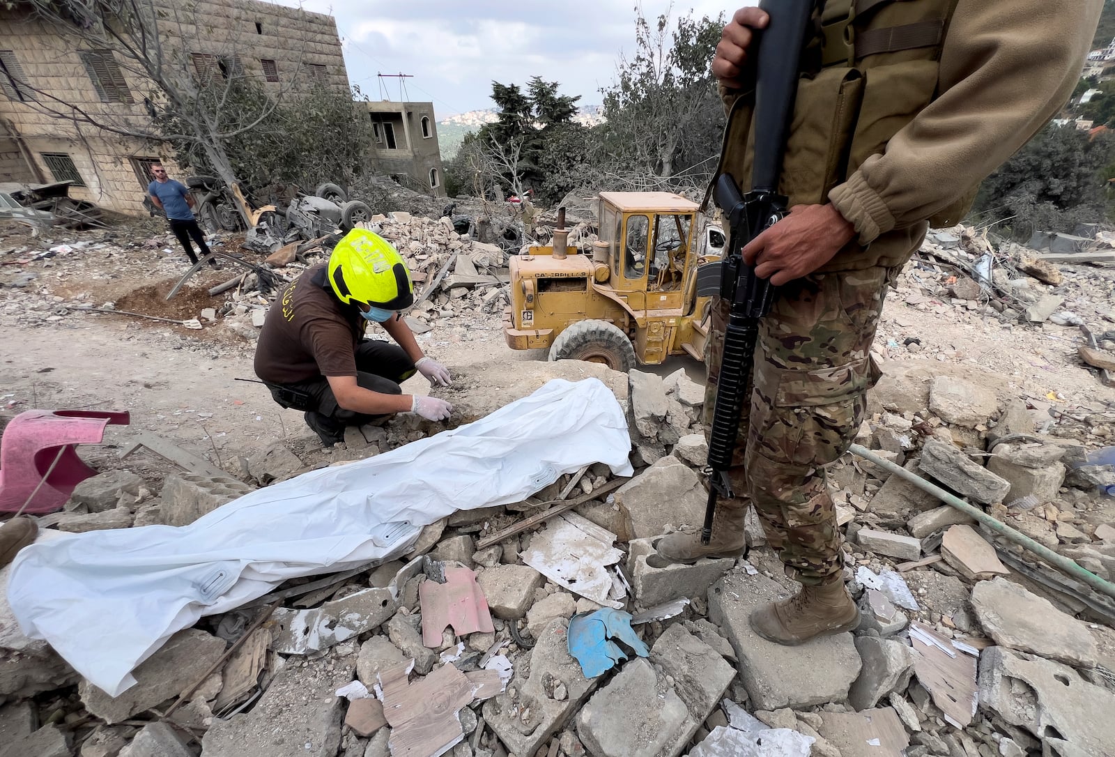 A Civil Defence worker searches for body remains between the rubble of a destroyed building at the site of Monday's Israeli airstrike in Aito village, north Lebanon, Tuesday, Oct. 15, 2024. (AP Photo/Hussein Malla)