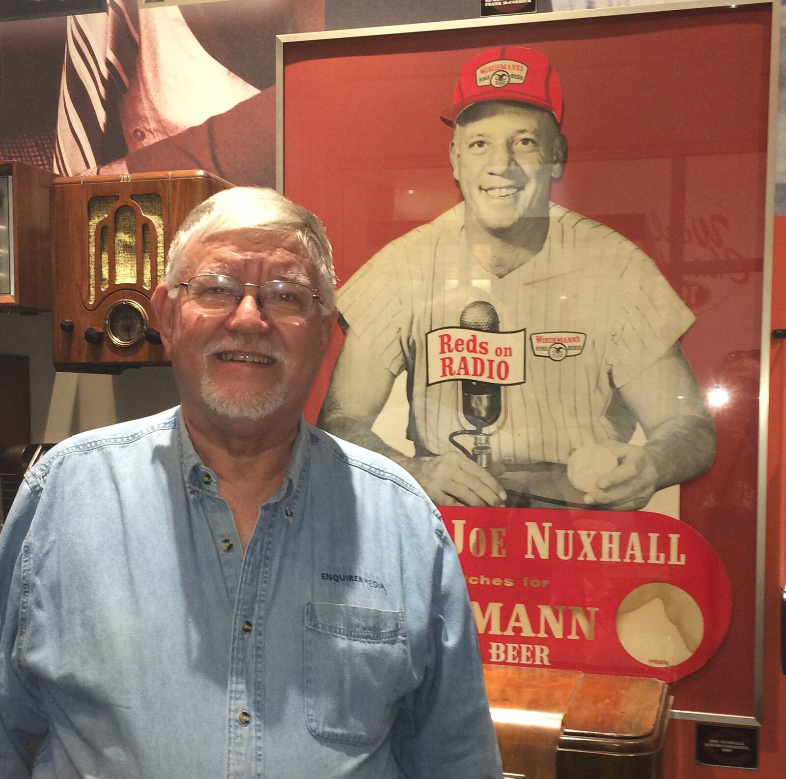 Author and Cincinnati Public Radio TV/Media reporter John Kiesewetter stands in front of Joe Nuxhall's Wiedemann Beer poster at the Reds Hall of Fame and Museum. He wrote "Joe Nuxhall: The Old Lefthander & Me," which is this weekend at JosephBeth Booksellers in Norwood, the Reds Hall of Fame and Museum in downtown Cincinnati and Roebling Point Books and Coffee in Covington. It's also available through at www.tvkiese.com and Amazon.com. PROVIDED