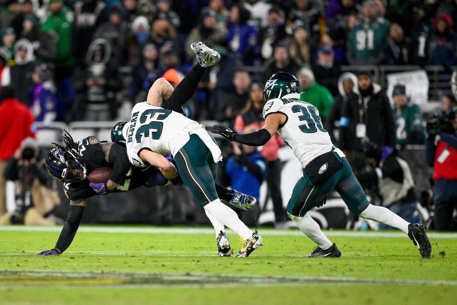 Baltimore Ravens running back Derrick Henry, left, is brought down by Philadelphia Eagles cornerback Cooper DeJean (33) and safety Tristin McCollum (36) during the second half of an NFL football game, Sunday, Dec. 1, 2024, in Baltimore. (AP Photo/Nick Wass)