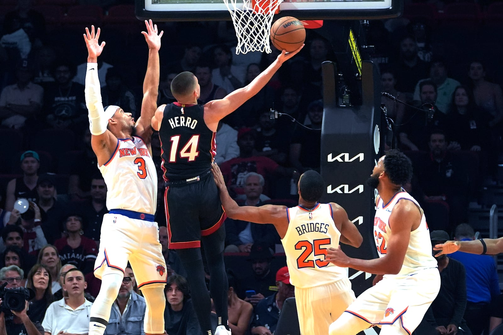 Miami Heat guard Tyler Herro (14) shoots over New York Knicks guard Josh Hart (3) and forward Mikal Bridges (25) during the first half of an NBA basketball game, Wednesday, Oct. 30, 2024, in Miami. (AP Photo/Lynne Sladky)