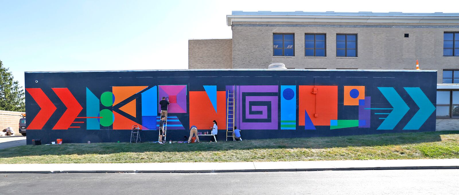 Artists and volunteers work on the new mural on the north side of The Career Connect Ed and The Dome building Monday, Sept. 9, 2024.