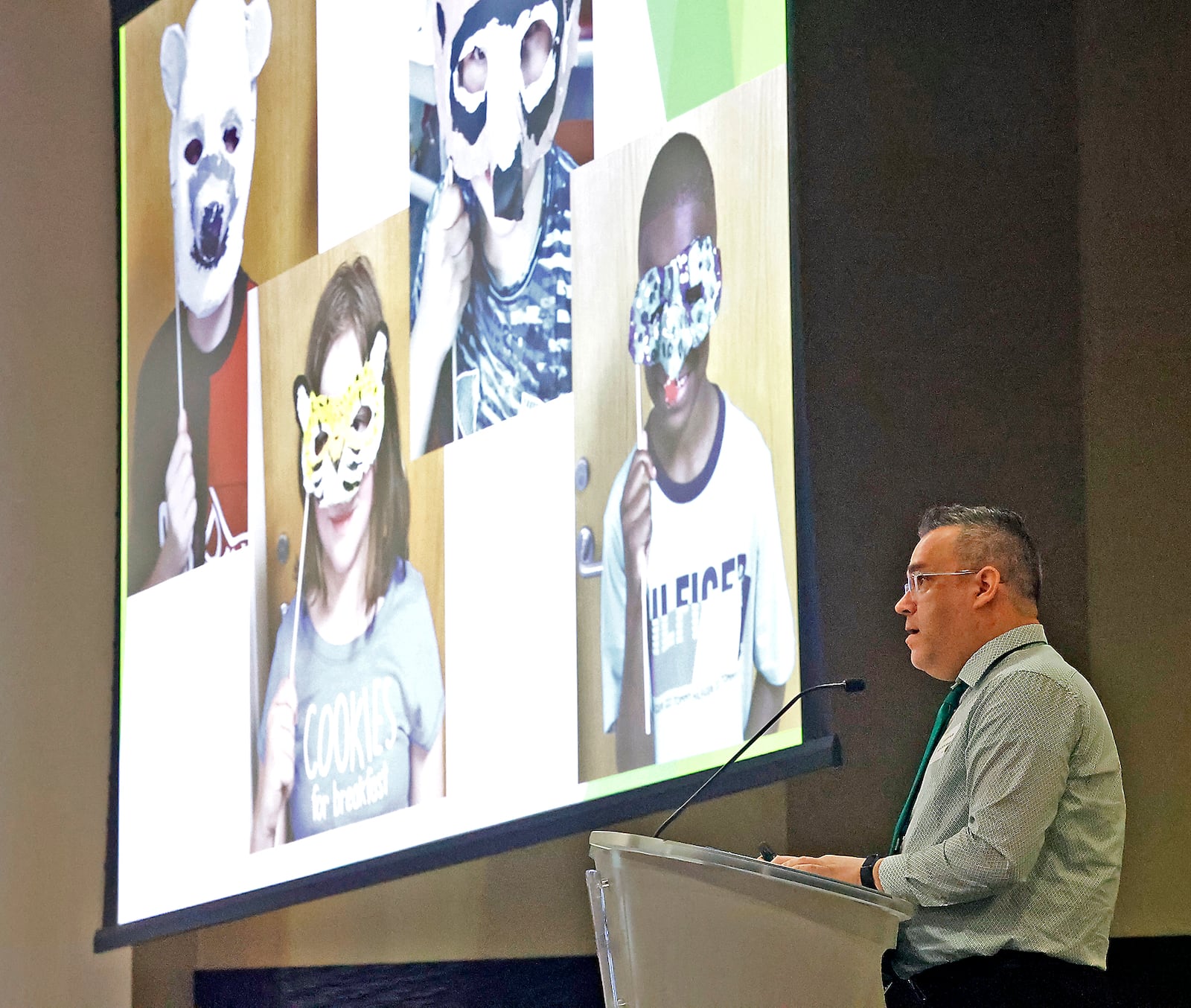 Joseph Fultz, one of the four Excellence in Teaching Award winners, showed photos of his students while he made his acceptance speech Monday, April 15, 2024 during the 35th Annual Excellence in Teaching Awards Program & Luncheon at the Hollenbeck Bayley Conference Center. BILL LACKEY/STAFF