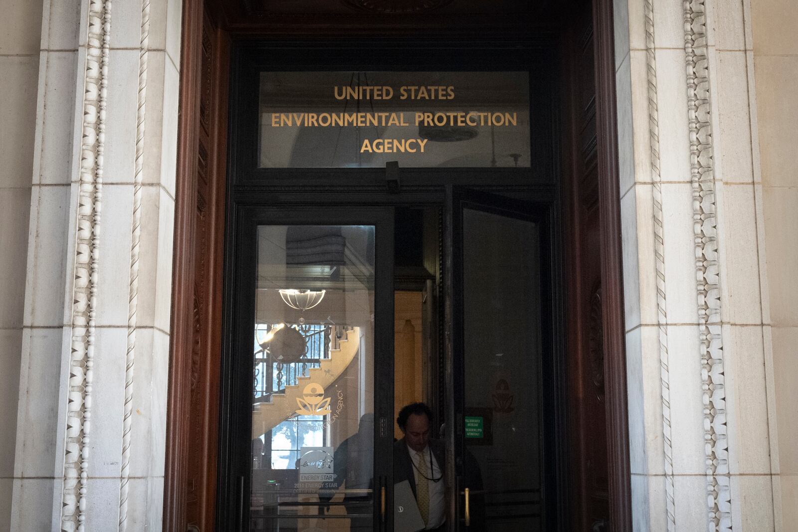 A person exits the headquarters building of the Environmental Protection Agency Wednesday, March 12, 2025, in Washington. (AP Photo/Mark Schiefelbein)