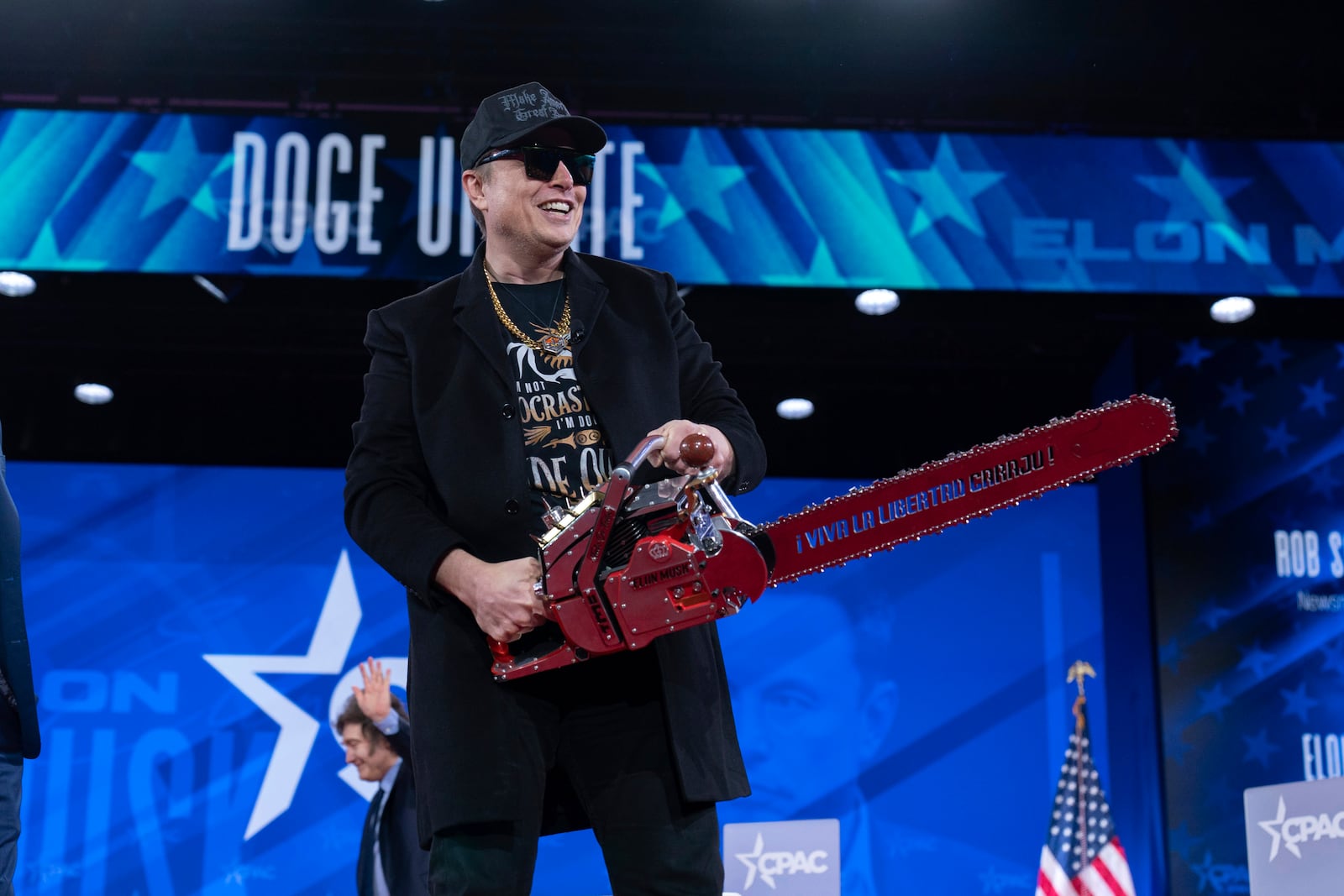 Elon Musk hold a chainsaw as he arrives to speak at the Conservative Political Action Conference, CPAC, at the Gaylord National Resort & Convention Center, Thursday, Feb. 20, 2025, in Oxon Hill, Md. (AP Photo/Jose Luis Magana)