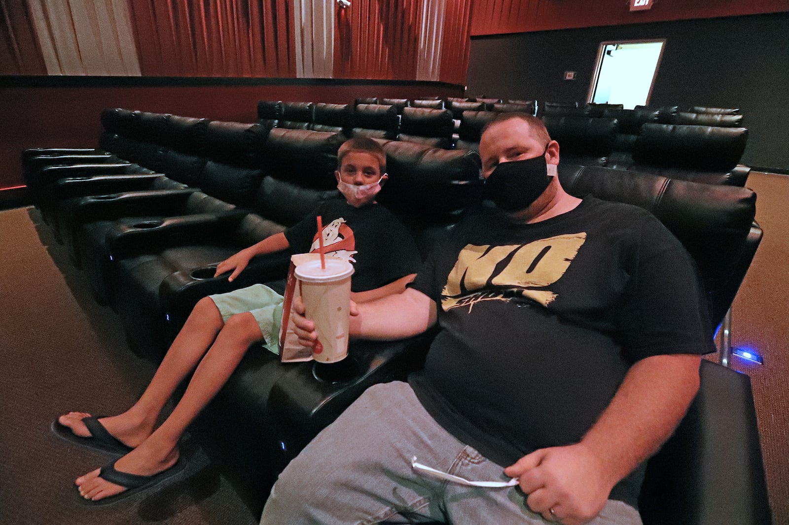 Jason Watson and his son, Ryan, get ready to watch "Back to the Future" Friday at the UEC Cinema 10 theater in Springfield. Friday was the first time in five months theaters have been opened. BILL LACKEY/STAFF