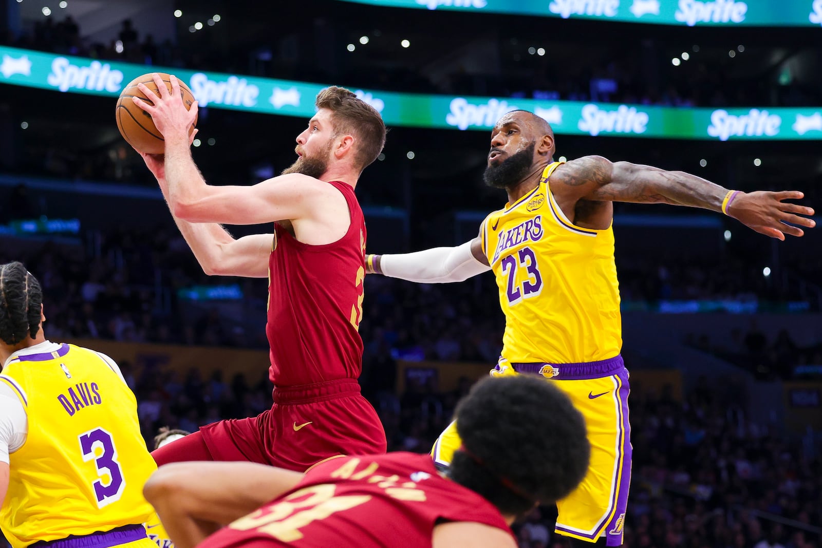 Cleveland Cavaliers forward Dean Wade, top left, drives past Los Angeles Lakers forward LeBron James (23) during the first half of an NBA basketball game Tuesday, Dec. 31, 2024, in Los Angeles. (AP Photo/Ryan Sun)