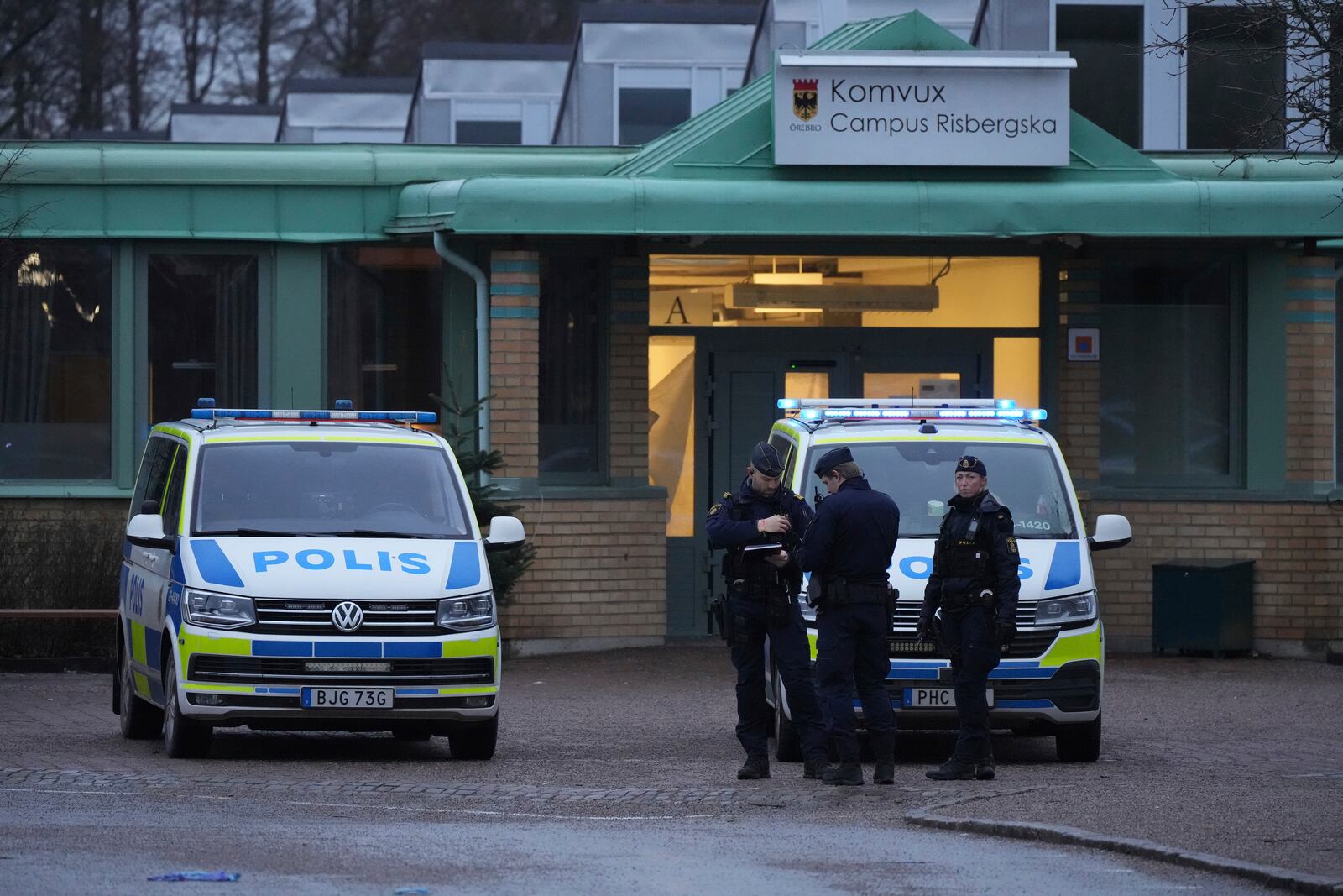 Police officers stand guard near the scene of a shooting at an adult education center on the outskirts of Orebro, Sweden, Wednesday, Feb. 5, 2025. (AP Photo/Sergei Grits)