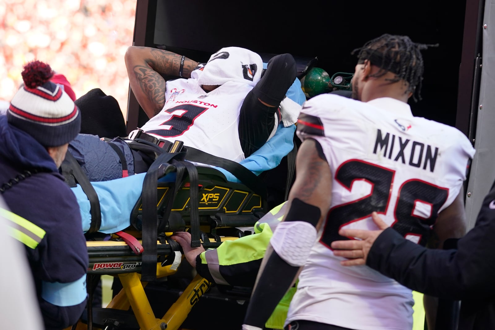 Houston Texans wide receiver Tank Dell covers his face as he is taken off the field on a stretcher after being injured while catching a touchdown pass during the second half of an NFL football game against the Kansas City Chiefs Saturday, Dec. 21, 2024, in Kansas City, Mo. (AP Photo/Ed Zurga)