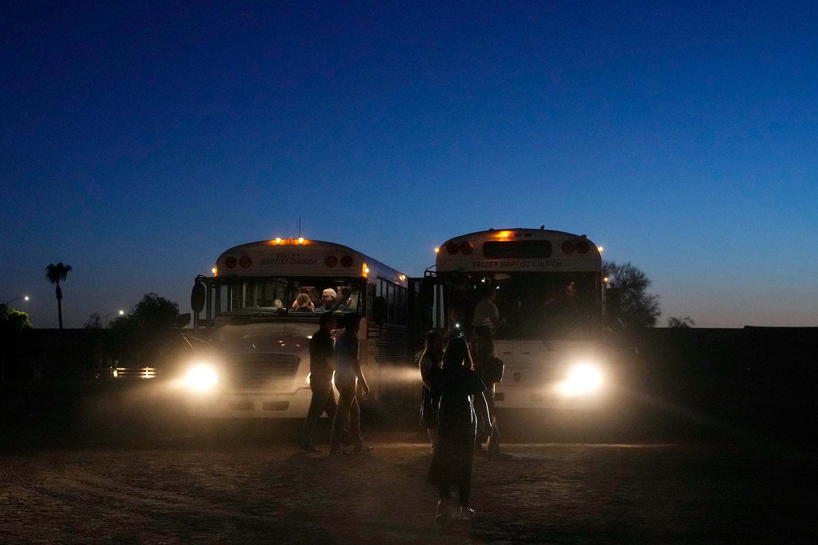 Buses get ready to depart with summer camp attendees at Valley Baptist Church, Tuesday, June 18, 2024, in Mesa, Ariz. (AP Photo/Ross D. Franklin)