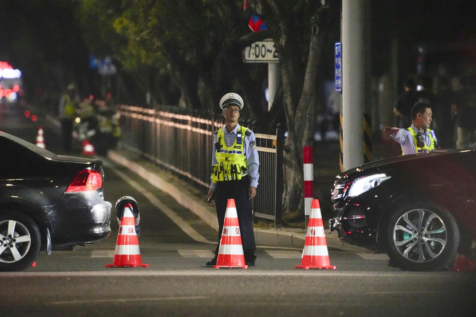 A security person stands guard near a sports center where a man rammed a car into people exercising in Zhuhai, China Monday, Nov. 11, 2024. (Kyodo News via AP)