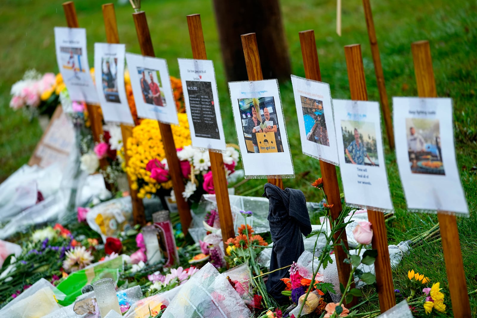 FILE - Rain-soaked memorials for those who died in a mass shooting sit along the roadside by Schemengees Bar & Grille, Oct. 30, 2023, in Lewiston, Maine. (AP Photo/Matt York, File)