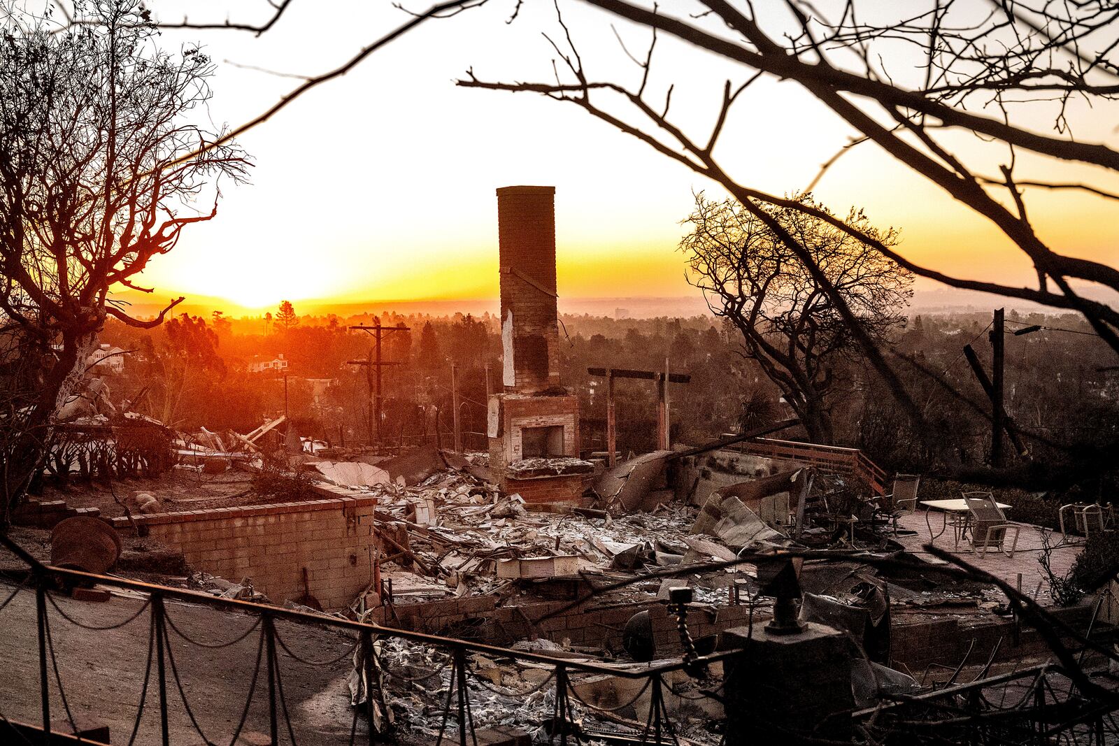 FILE - The sun rises behind a home destroyed by the Palisades Fire in the Pacific Palisades community of Los Angeles on Sunday, Jan. 12, 2025, (AP Photo/Noah Berger, File)