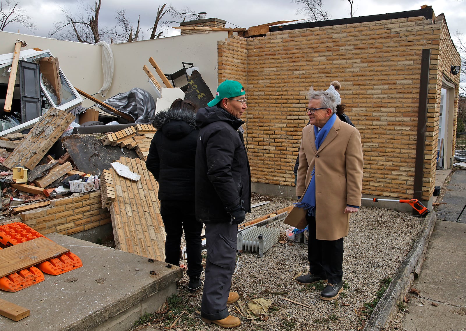 Governor Mike DeWine talks to Shoji Uota and Emi Campbell at their home on Ridge Road that was destroyed by a tornado early Wednesday morning. BILL LACKEY/STAFF