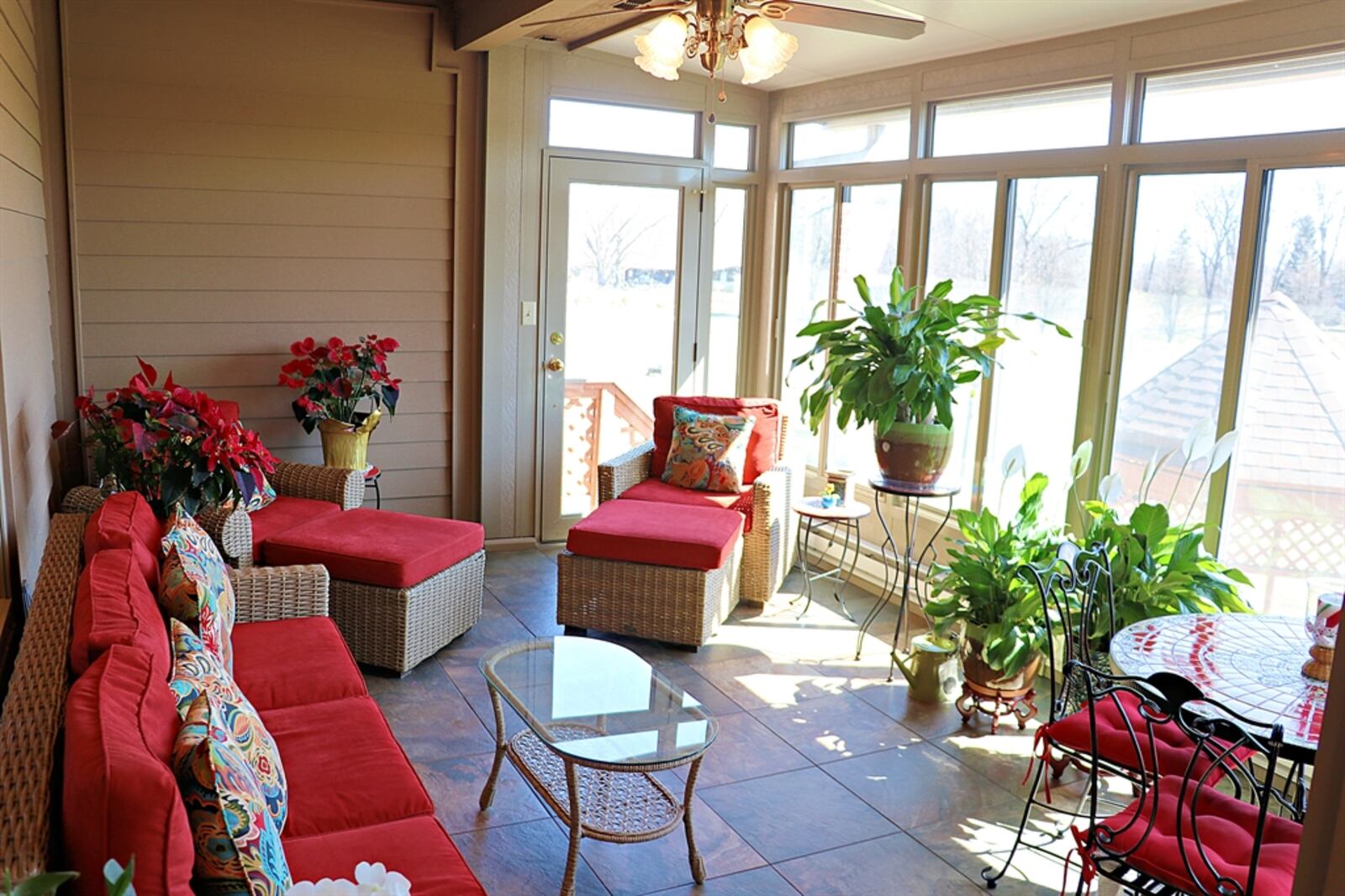 A glass door opens from the breakfast room out to a four-season room with ceramic-tile flooring, ceiling fans and speakers. 