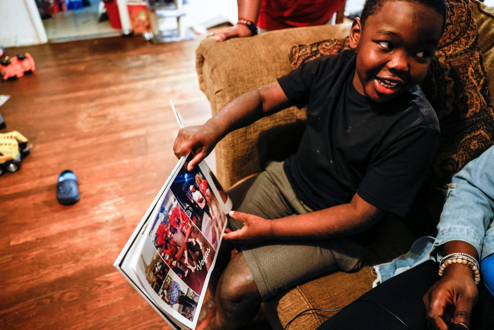 Willie Edwards Jr. looks through photos of his father, Willie Edwards, before dinner at the family's home in Harrison Twp. Willie Edwards Jr. lost his father, Willie Edwards Sr., to COVID-19 in August. JIM NOELKER/STAFF