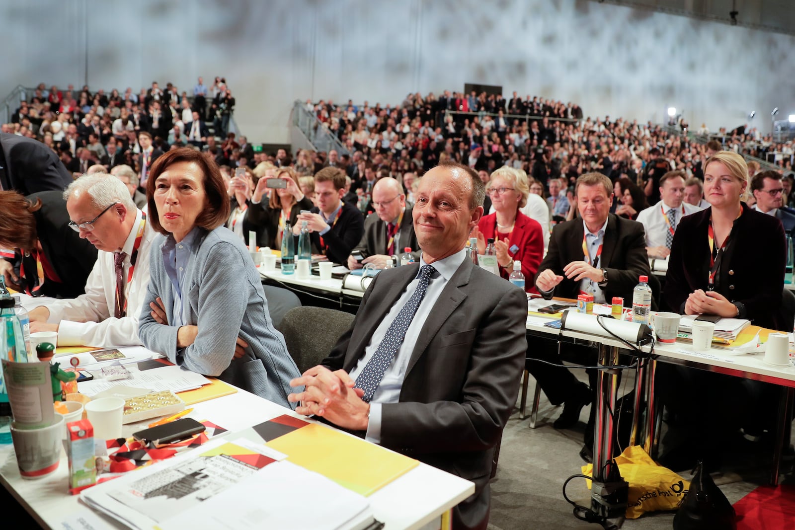 FILE - Friedrich Merz, center, party member and candidate for the party chairmanship, smiles after his speech during a party convention of the Christian Democratic Union party (CDU) in Hamburg, Germany, Dec. 7, 2018. (AP Photo/Markus Schreiber, File)