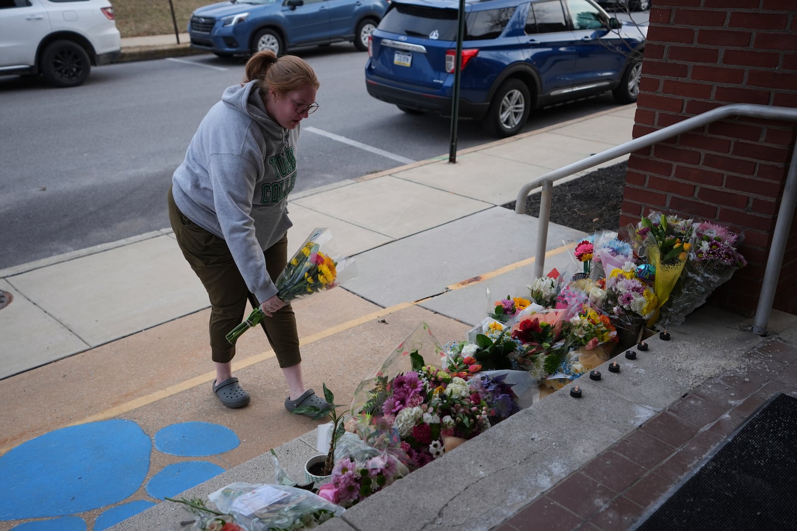 A person places flowers in front of the West York Police Department after a police officer was killed responding to a shooting at UPMC Memorial Hospital in York, Pa. on Saturday, Feb. 22, 2025. (AP Photo/Matt Rourke)