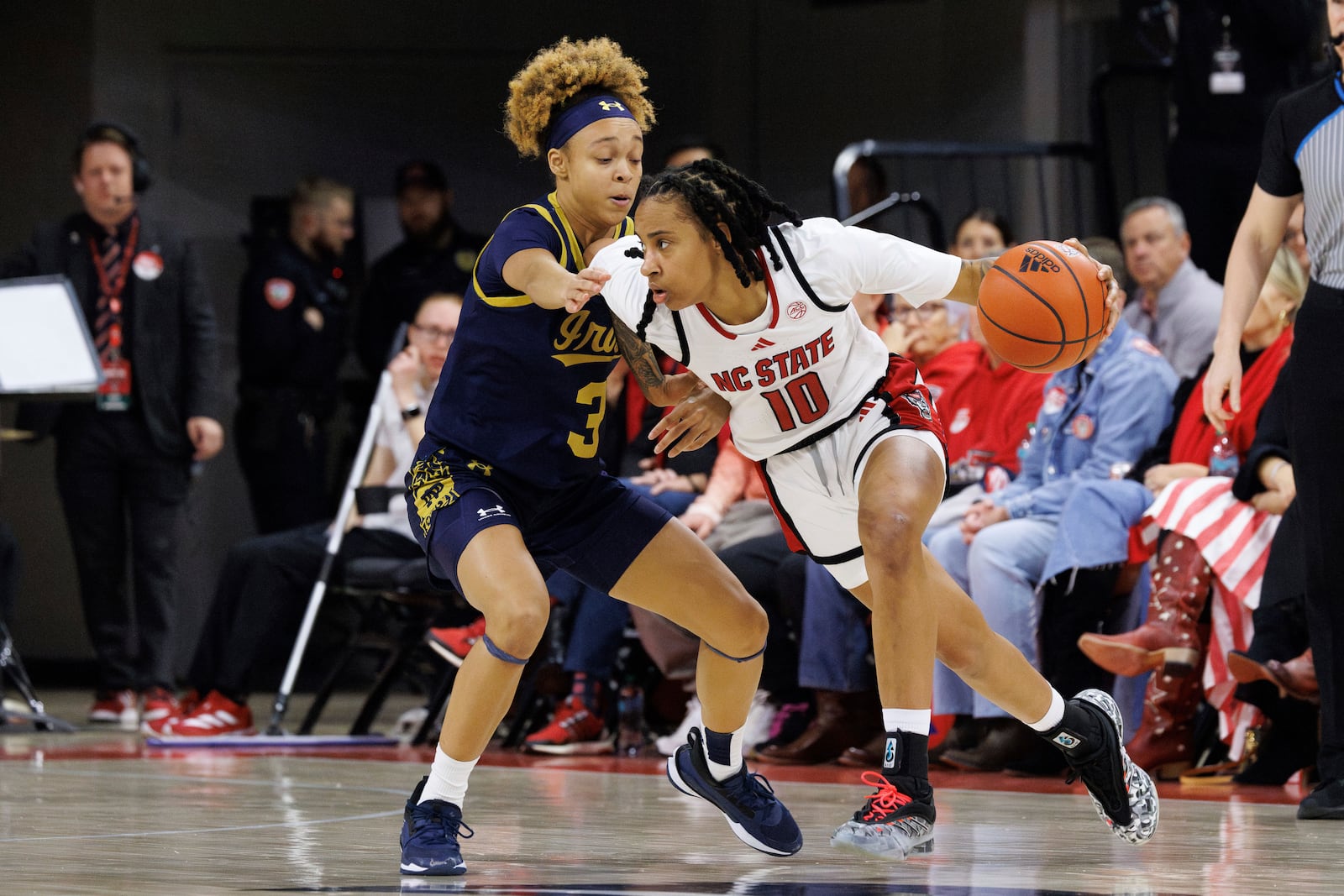 NC State's Aziaha James (10) handles the ball as Notre Dame's Hannah Hidalgo (3) defends during the first half of an NCAA college basketball game in Raleigh, N.C., Sunday, Feb. 23, 2025. (AP Photo/Ben McKeown)