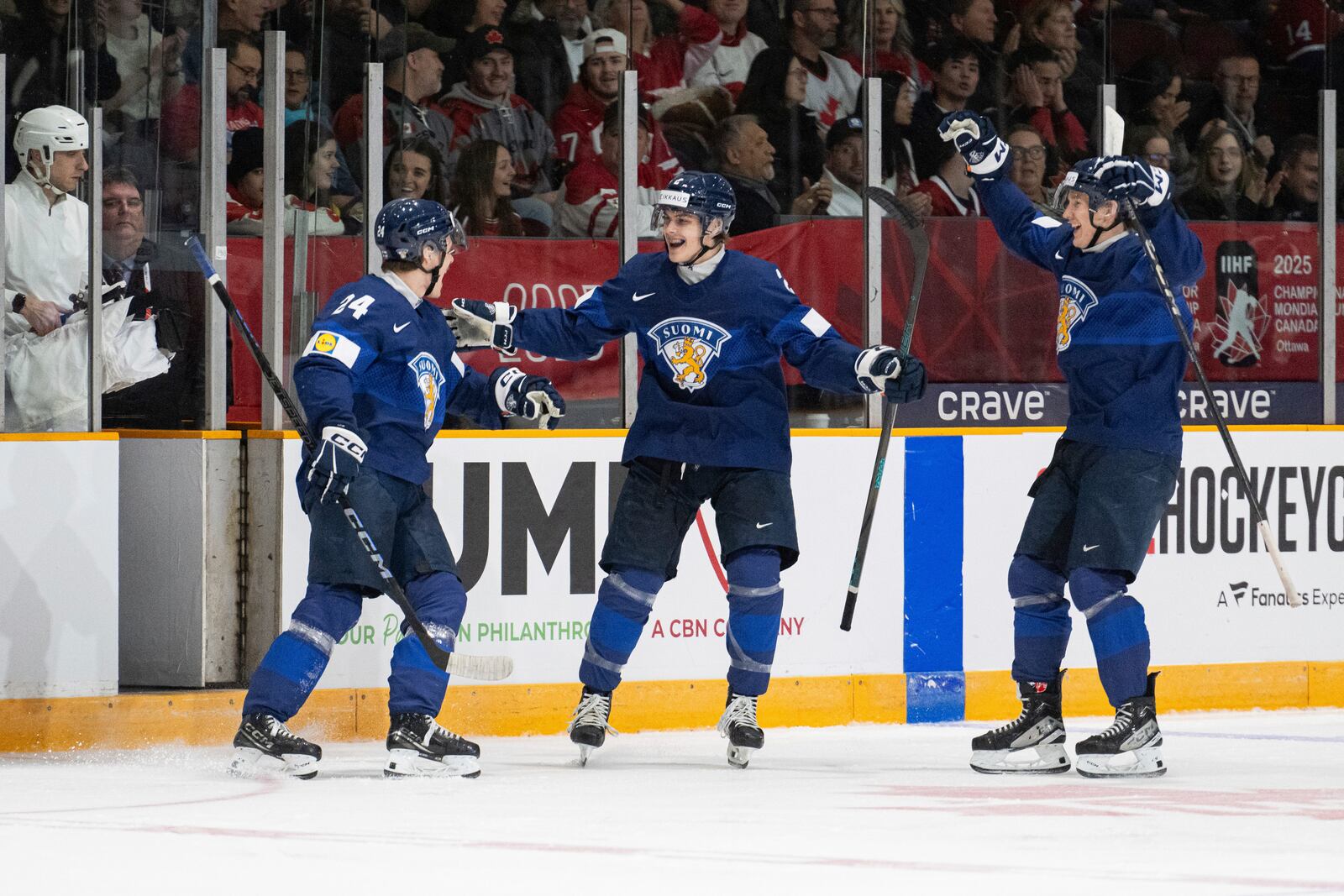 Finland forward Jesse Nurmi (24) celebrates his goal with teammates Mitja Jokinen (2) and Daniel Nieminen (7) during the first period of an IIHF World Junior Hockey Championship quarterfinal match against Slovakia in Ottawa, Ontario Thursday, Jan. 2, 2025. (Spencer Colby/The Canadian Press via AP)