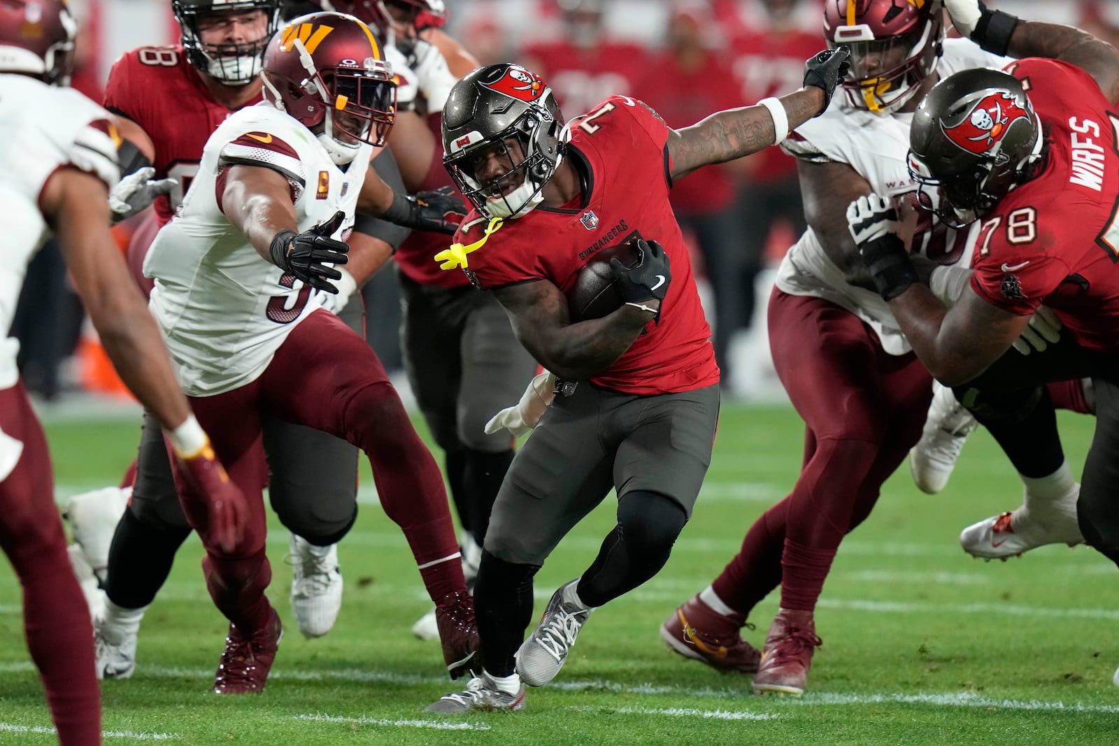 Tampa Bay Buccaneers running back Bucky Irving, middle, runs against the Washington Commanders during the second half of an NFL wild-card playoff football game in Tampa, Fla., Sunday, Jan. 12, 2025. (AP Photo/Chris O'Meara)